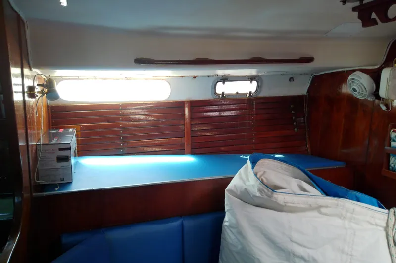 Slide: The Image of Interior of a 1972 Morgan Out Island 41 sailboat with wooden paneling and blue seating. - 27
