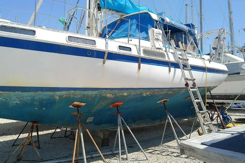 Slide: The Image of 1972 Morgan Out Island 41 sailboat on stands, undergoing maintenance in a boatyard. - 3