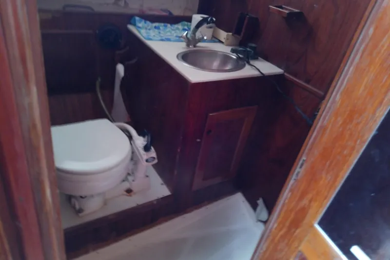 Slide: The Image of 1972 Morgan Out Island 41 yacht bathroom with wooden cabinetry, sink, and marine toilet. - 33