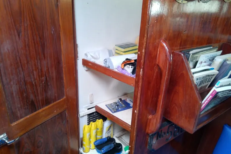 Slide: The Image of Interior of a 1972 Morgan Out Island 41 sailboat with wooden shelves and books. - 34