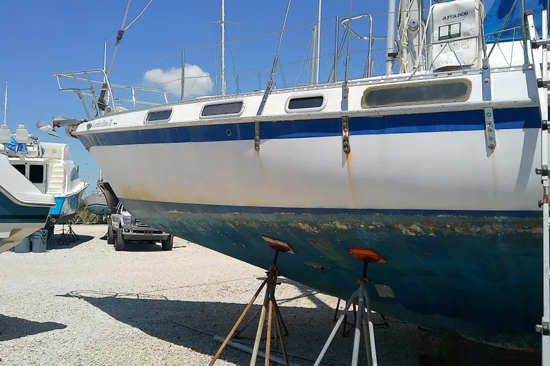 Slide: The Image of 1972 Morgan Out Island 41 sailboat on stands, showing weathered hull and deck details. - 4