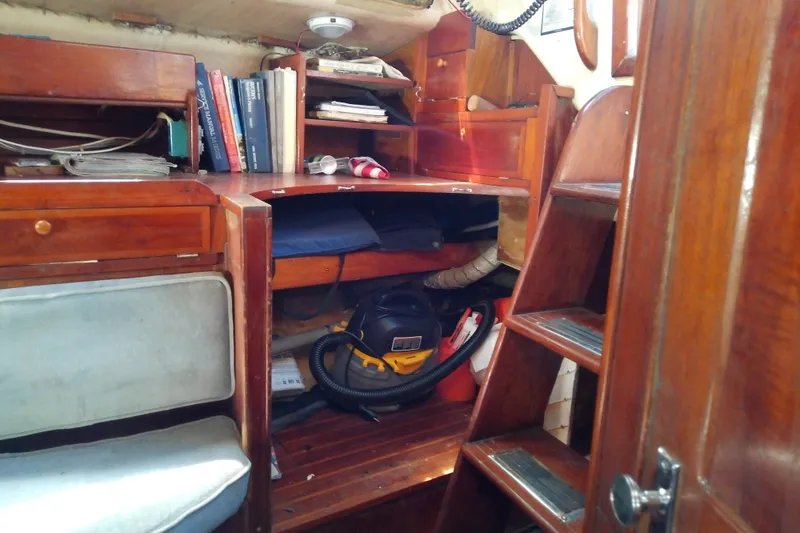 Slide: The Image of Interior of 1972 Morgan Out Island 41 sailboat with wooden cabinetry and storage shelves. - 44