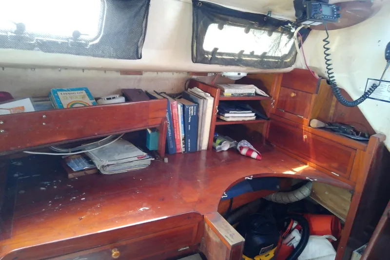 Slide: The Image of Interior of a 1972 Morgan Out Island 41 sailboat with wooden desk and shelves. - 45