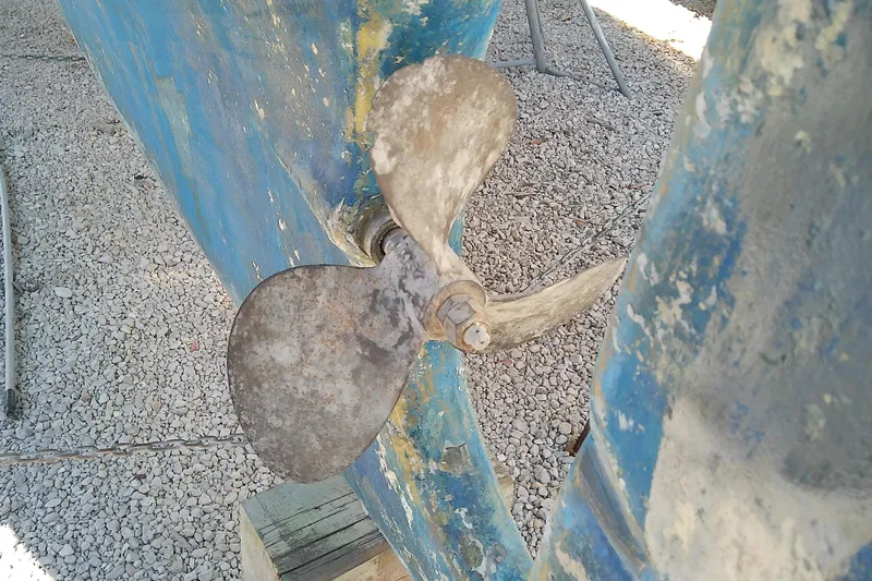 Slide: The Image of Propeller of a 1972 Morgan Out Island 41 sailboat on gravel surface. - 6