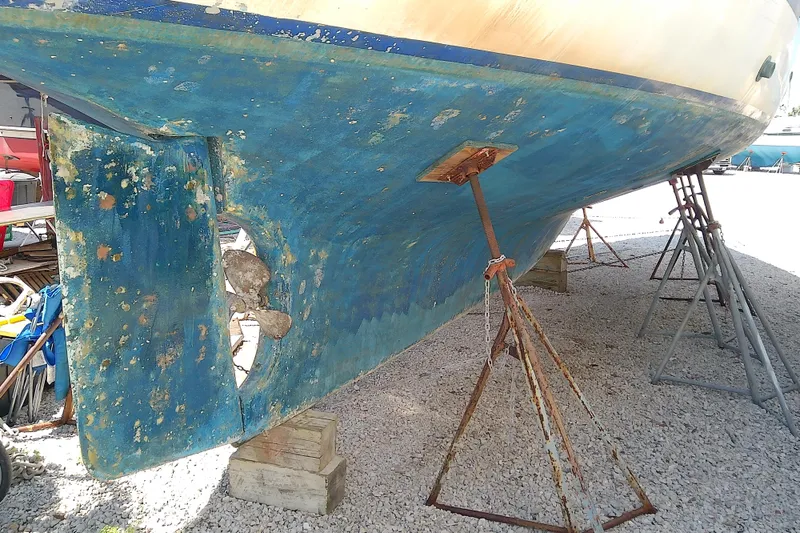 Slide: The Image of 1972 Morgan Out Island 41 sailboat hull on stands, showing wear and propeller. - 7