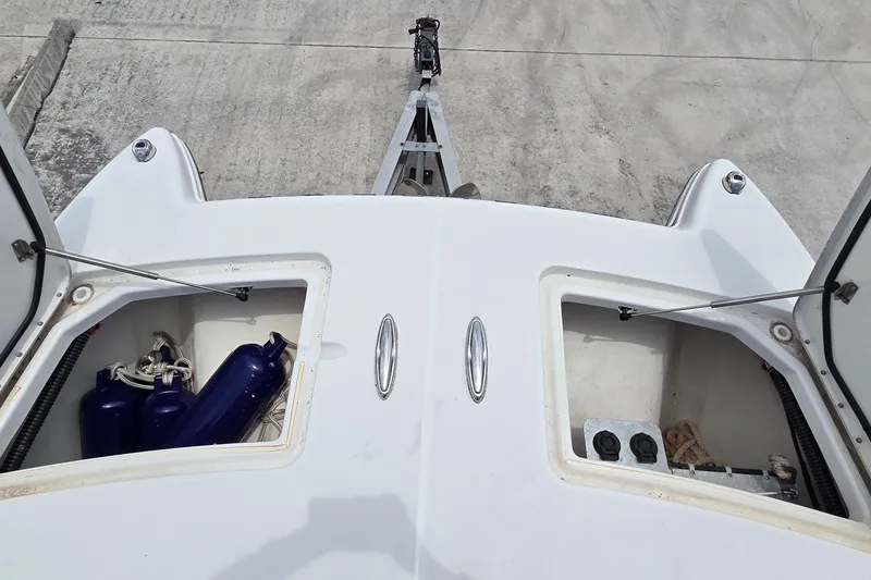 Slide: The Image of 2023 World Cat 280 DC-X boat storage compartments with fenders and ropes on a trailer. - 13