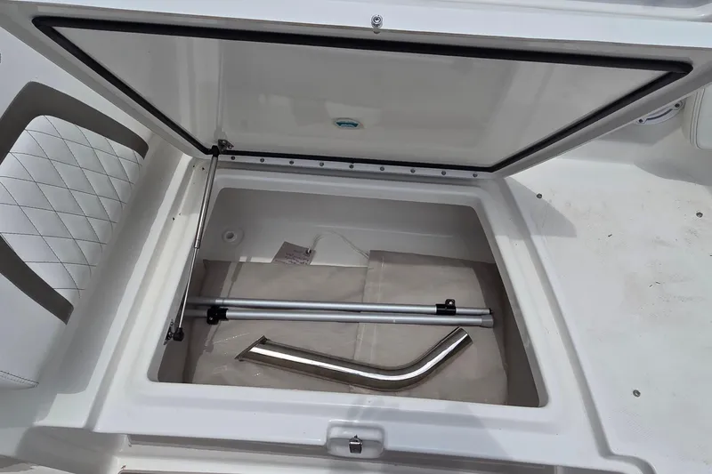 Slide: The Image of Open storage compartment in 2023 World Cat 280 DC-X boat, featuring metal rods and accessories. - 16