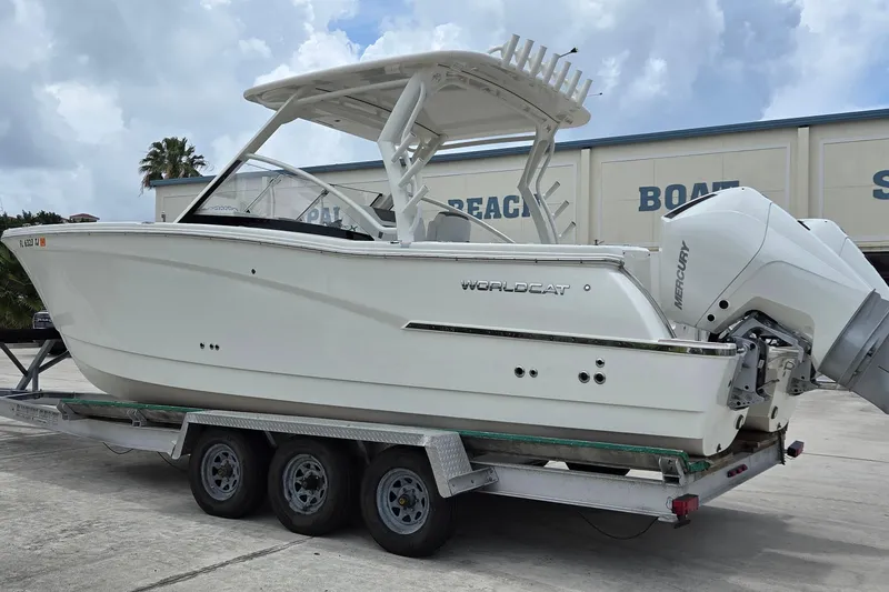 Slide: The Image of 2023 World Cat 280 DC-X boat on trailer, featuring dual Mercury engines. - 2