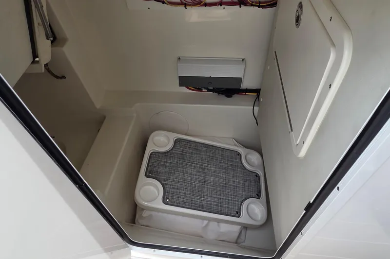 Slide: The Image of Interior of 2023 World Cat 280 DC-X boat, featuring storage compartment and electrical panel. - 21