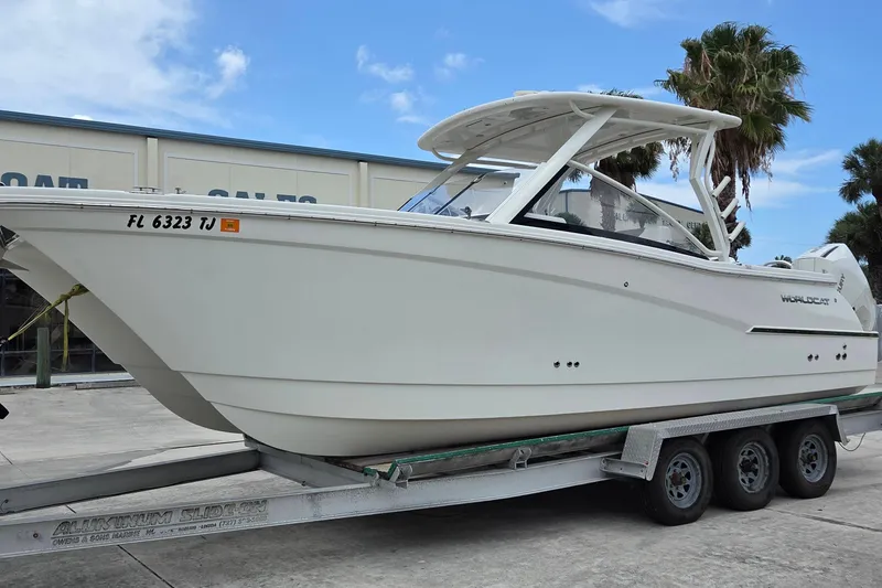 Slide: The Image of 2023 World Cat 280 DC-X boat on trailer, parked outdoors under blue sky. - 3