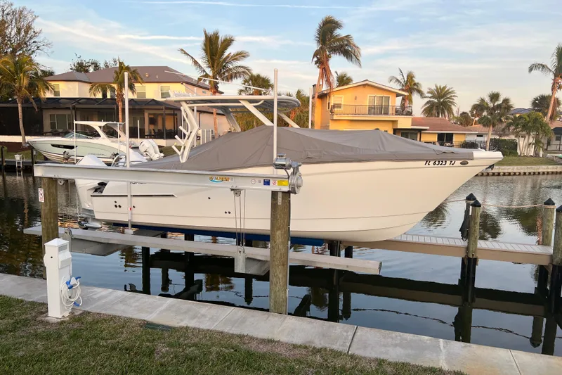 Slide: The Image of 2023 World Cat 280 DC-X boat docked in a scenic waterfront setting. - 34