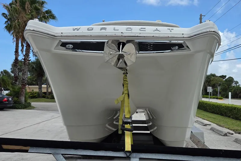 Slide: The Image of 2023 World Cat 280 DC-X boat on trailer, front view with anchor, palm trees in background. - 4