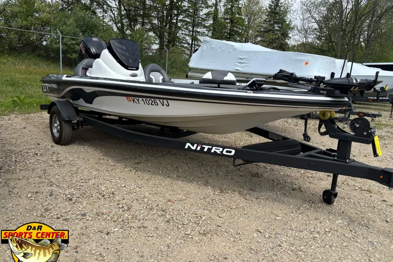 Slide: The Image of 2025 Nitro Z17 boat on trailer, parked outdoors with trees in background. - 2