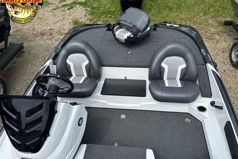 Slide: The Image of 2025 Nitro Z17 boat interior with gray seating and steering wheel, parked on gravel. - 8