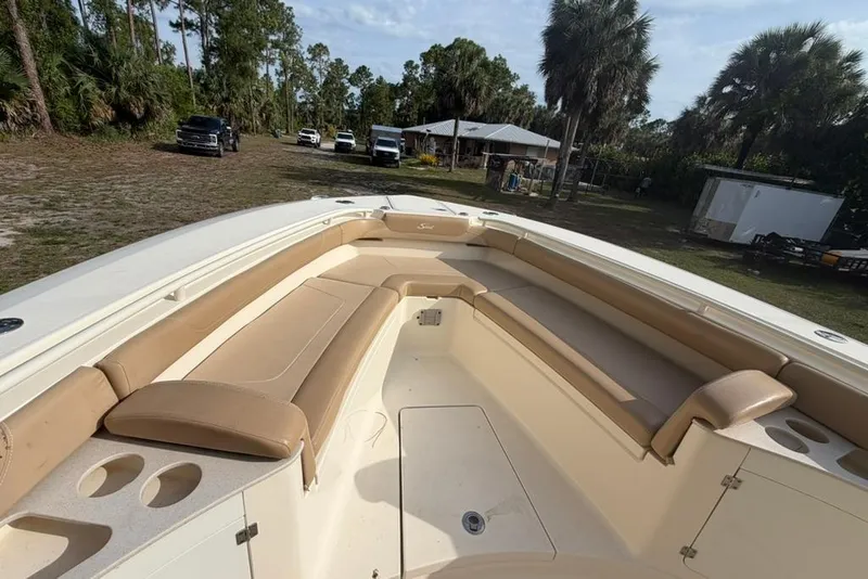 Slide: The Image of 2019 Scout 275 LXF boat with spacious seating and cup holders, parked outdoors. - 11