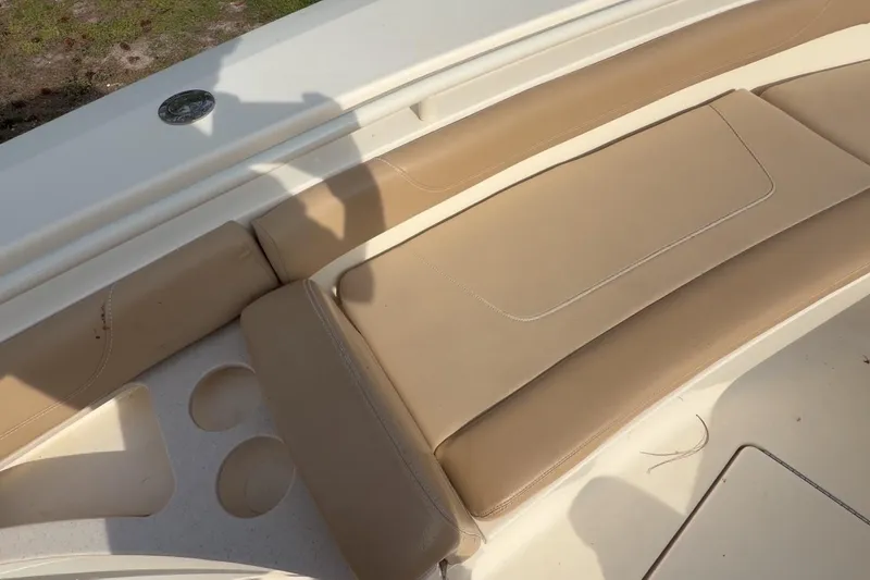 Slide: The Image of 2019 Scout 275 LXF boat with beige cushioned seating and cup holders. - 14