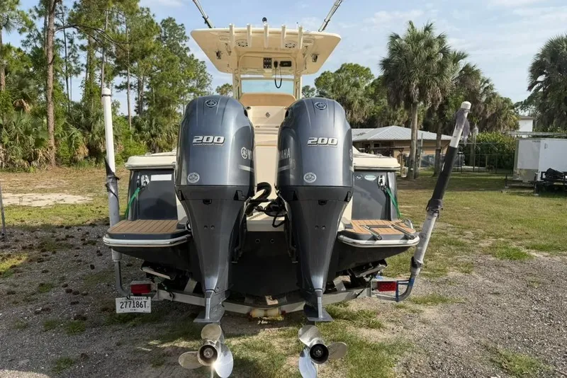 Slide: The Image of 2019 Scout 275 LXF boat with dual Yamaha 200 engines, parked outdoors. - 4