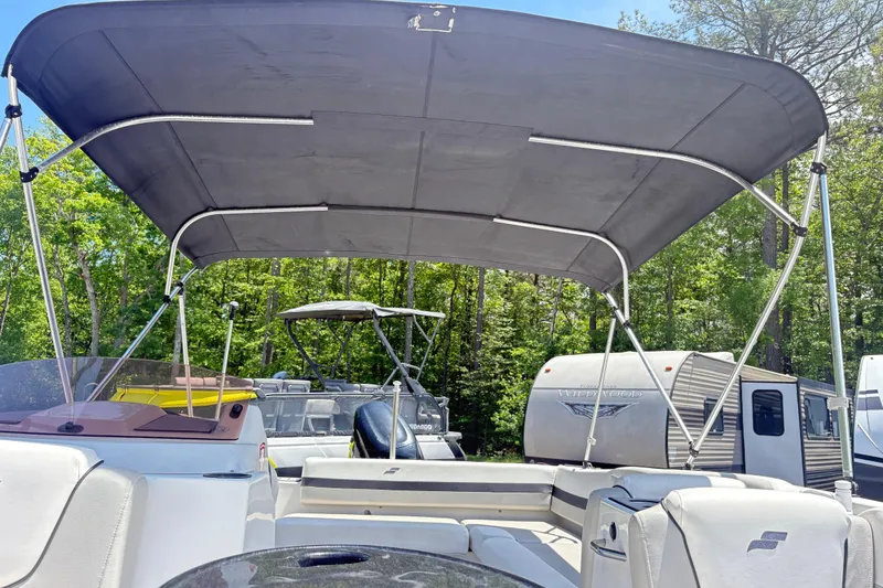 Slide: The Image of 2022 Starcraft SVX 191 OB boat with canopy, parked near RVs and trees. - 6