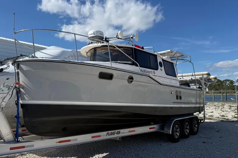The Image of 2024 Ranger Tugs R-27 boat on trailer under blue sky. - 0