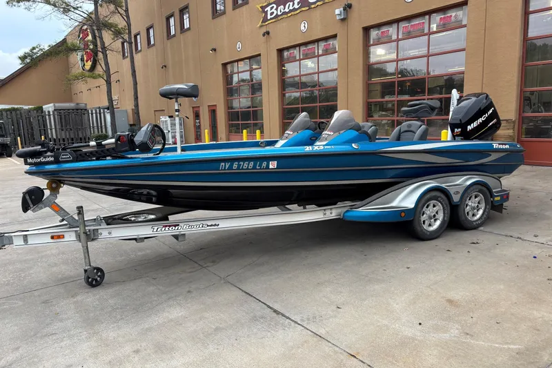 The Image of 2009 Triton 22 TrX boat on trailer, parked outside a building. - 0