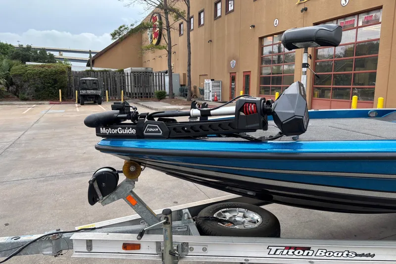 Slide: The Image of 2009 Triton 22 TrX boat with MotorGuide Tour motor on trailer, parked outdoors. - 2