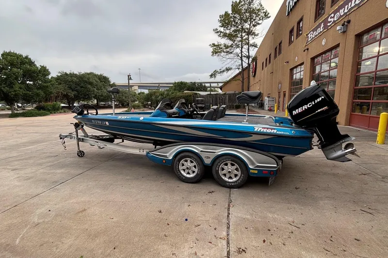 Slide: The Image of 2009 Triton 22 TrX boat with Mercury engine on trailer, parked outside service center. - 11