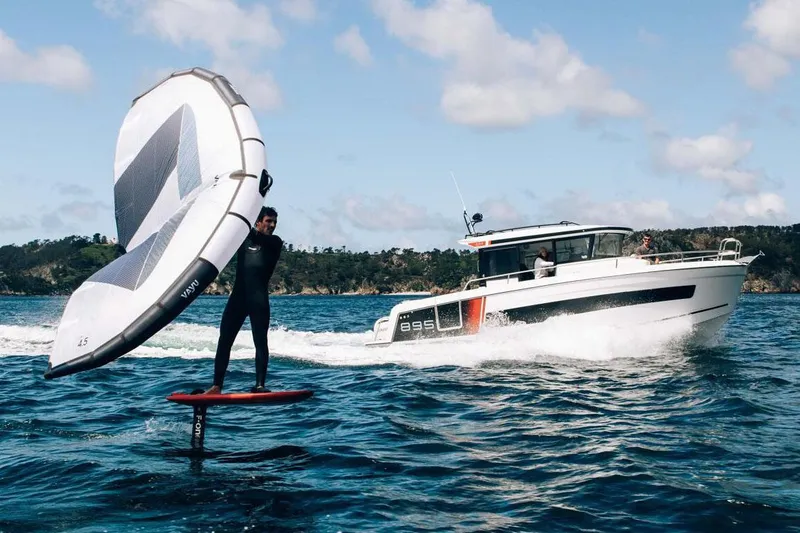 Slide: The Image of Manufacturer Provided Image: Man wingfoiling near 2026 Jeanneau NC 895 Sport Series 2 boat on open water. - 3