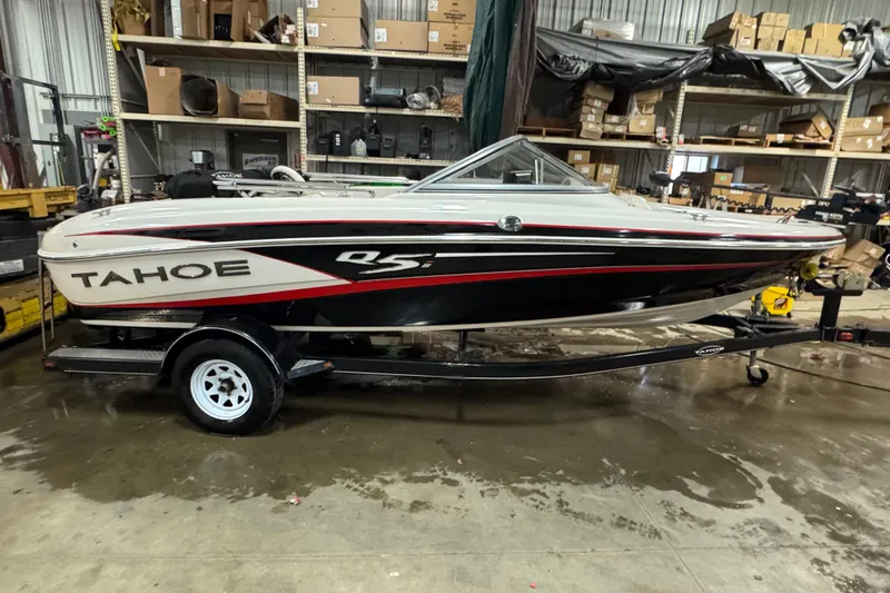 The Image of 2013 Tahoe Q5i boat on trailer in warehouse setting. - 0