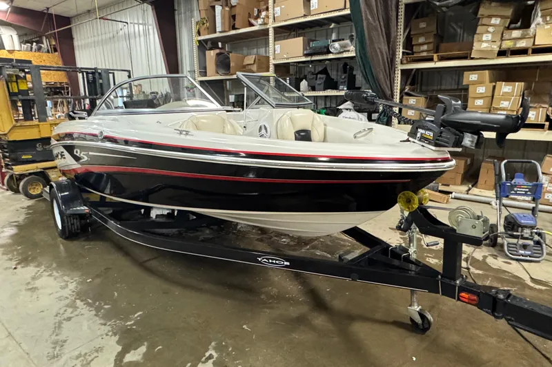Slide: The Image of 2013 Tahoe Q5i boat on trailer in warehouse setting. - 2