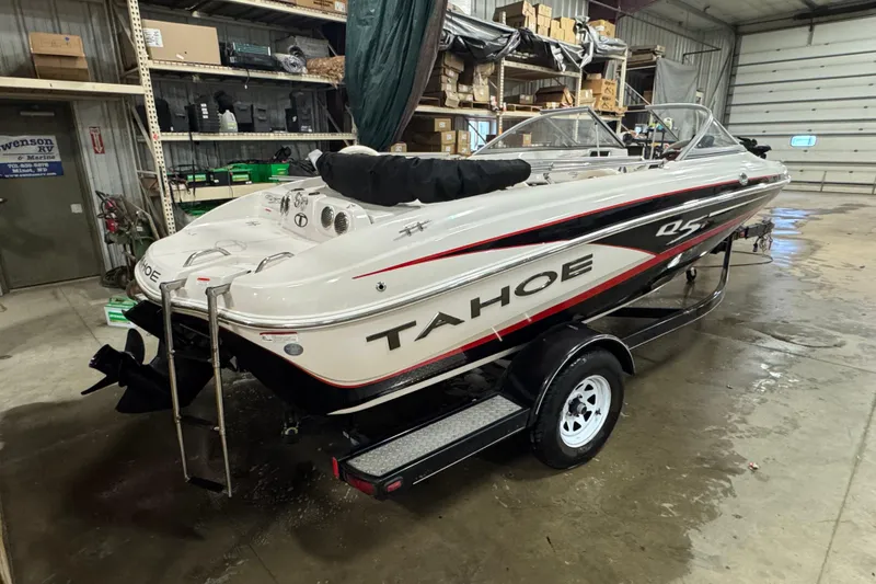 Slide: The Image of 2013 Tahoe Q5i boat in a garage, on a trailer, with visible storage shelves. - 3