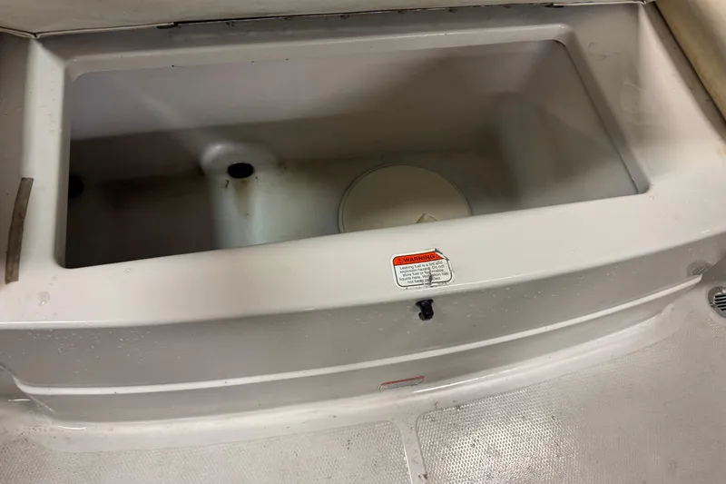 Slide: The Image of Storage compartment in a 2013 Tahoe Q5i boat, featuring a warning label. - 9