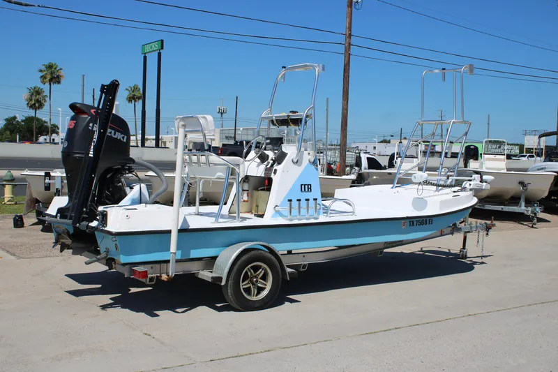 Slide: The Image of 2017 CCB Phoenix boat on trailer with Suzuki outboard motor, parked outdoors. - 6