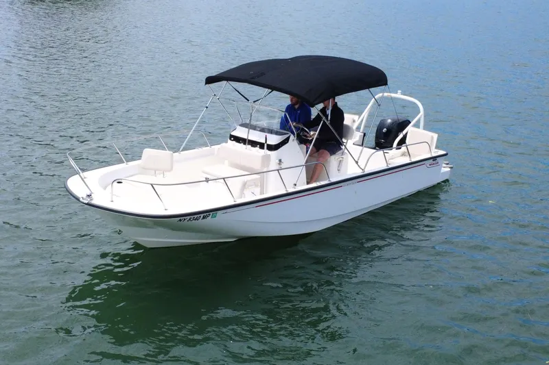The Image of 2020 Boston Whaler 210 Montauk boat on water with canopy and passengers. - 0