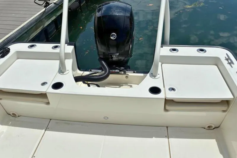Slide: The Image of 2020 Boston Whaler 210 Montauk boat with outboard motor, docked on calm water. - 10