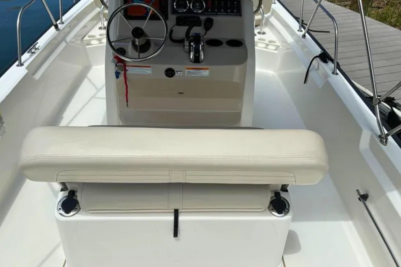 Slide: The Image of Interior view of a 2020 Boston Whaler 210 Montauk boat, featuring helm and seating. - 12