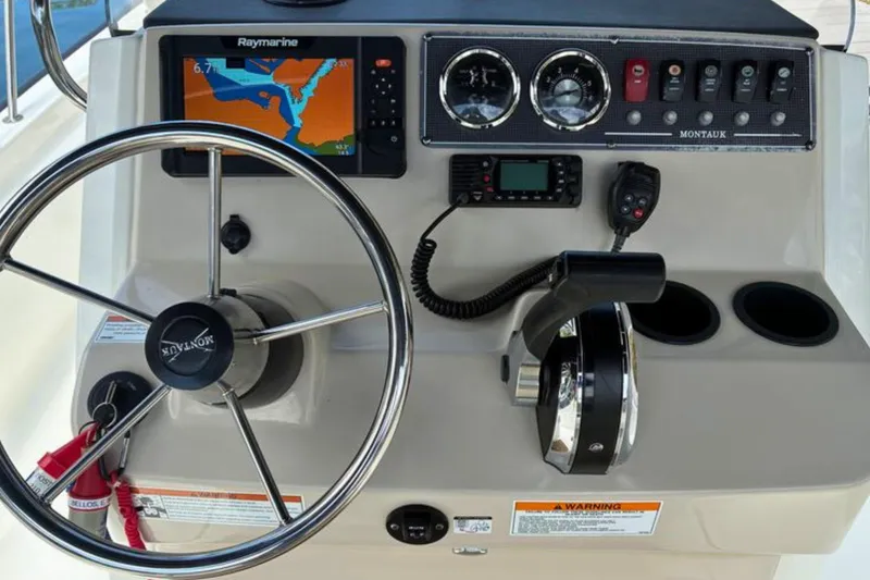 Slide: The Image of 2020 Boston Whaler 210 Montauk dashboard with steering wheel and navigation controls. - 15
