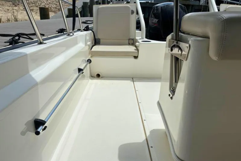Slide: The Image of Interior view of a 2020 Boston Whaler 210 Montauk boat, showcasing seating and railing. - 16
