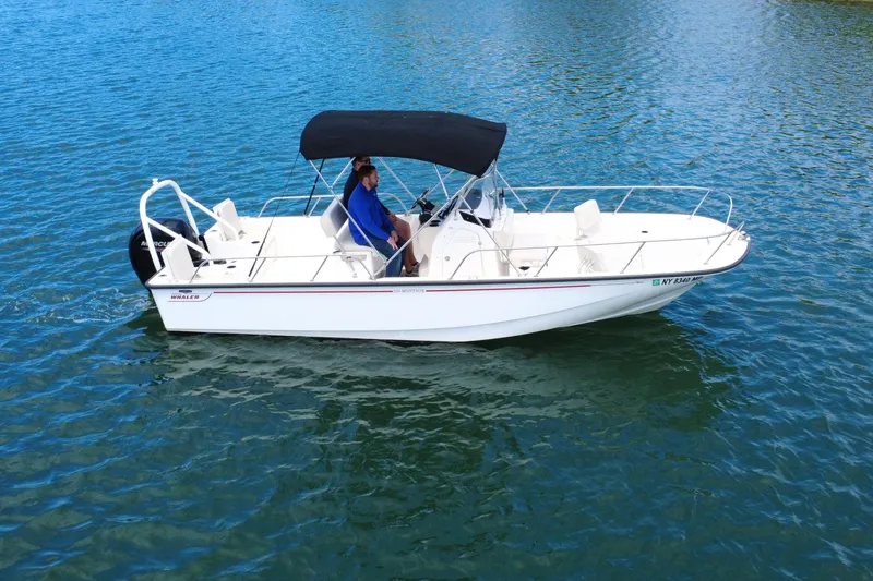 Slide: The Image of 2020 Boston Whaler 210 Montauk boat cruising on clear blue water. - 2