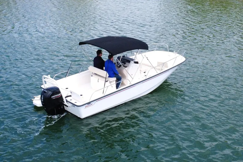 Slide: The Image of 2020 Boston Whaler 210 Montauk boat cruising on water with two passengers. - 5
