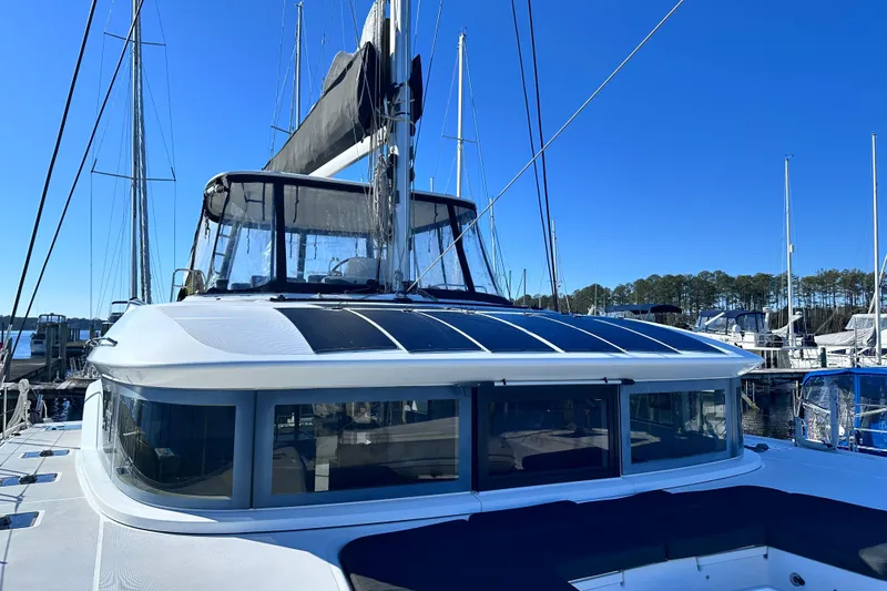 The Image of 2023 Lagoon 50 catamaran docked at marina under clear blue sky. - 1