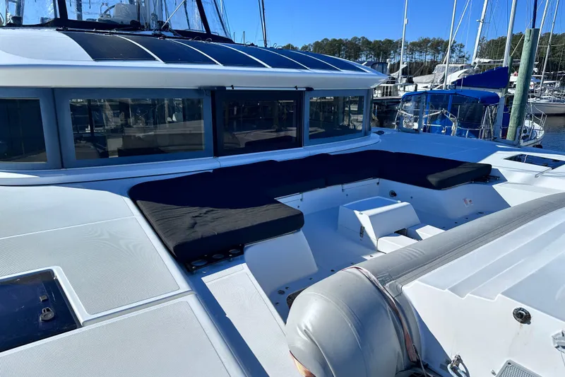 Slide: The Image of 2023 Lagoon 50 yacht deck with seating area in marina setting. - 13