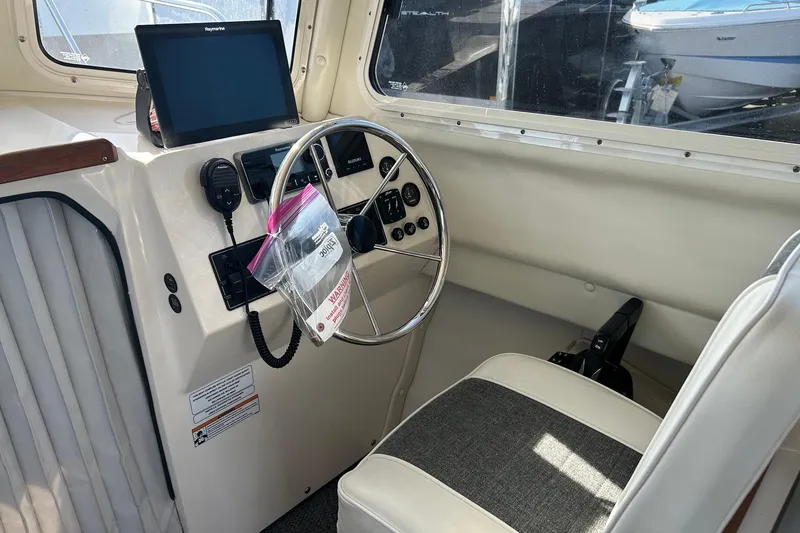 Slide: The Image of 2018 C-Dory 23' Venture boat interior with steering wheel and navigation equipment. - 12