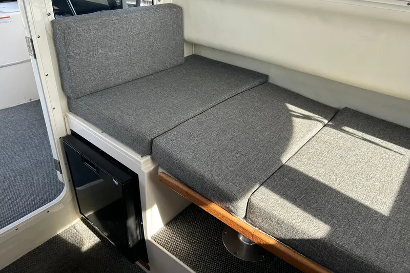 Slide: The Image of Interior seating area of a 2018 C-Dory 23' Venture boat with gray cushions. - 14