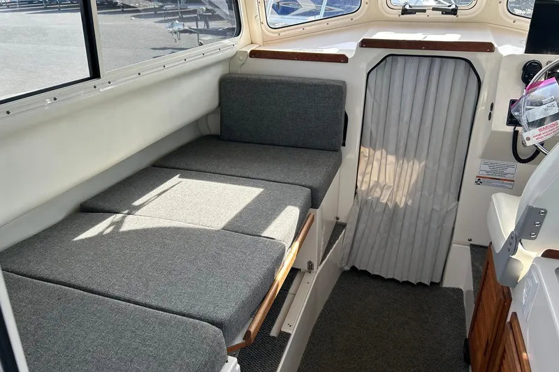 Slide: The Image of Interior of a 2018 C-Dory 23' Venture boat with gray cushioned seating. - 15