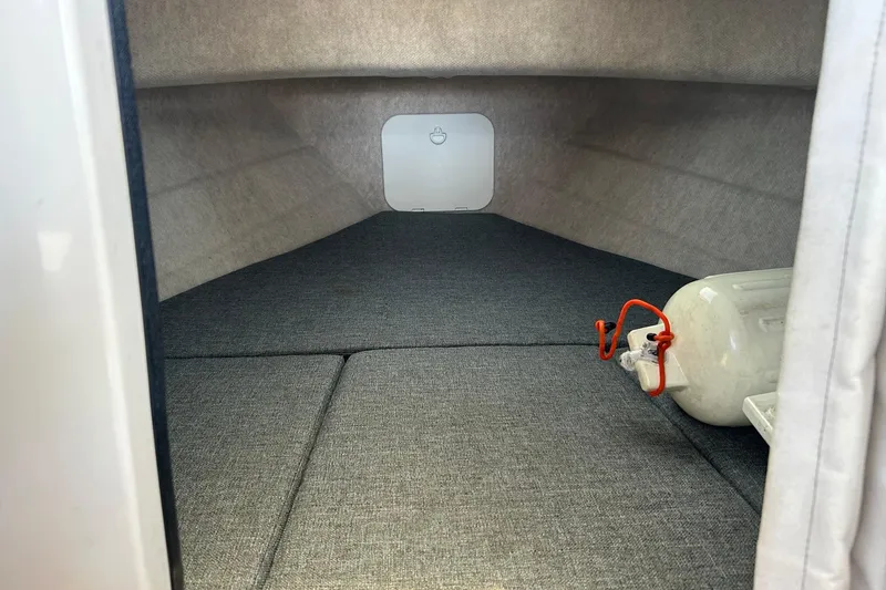 Slide: The Image of Interior cabin of 2018 C-Dory 23' Venture boat, featuring gray upholstery and storage space. - 16
