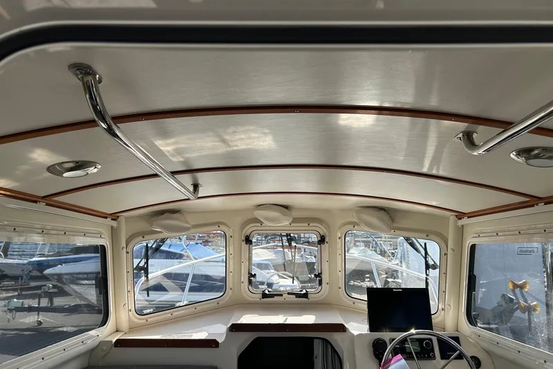 Slide: The Image of Interior view of 2018 C-Dory 23' Venture boat cabin with windows and steering wheel. - 18