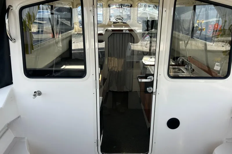 Slide: The Image of 2018 C-Dory 23' Venture boat interior with kitchenette and seating area. - 9