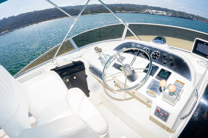 Slide: The Image of Pilothouse of 2004 Meridian 490 yacht with steering wheel and control panel, overlooking water. - 10