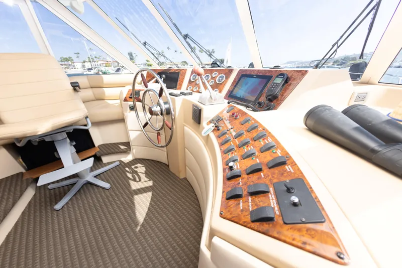 Slide: The Image of 2004 Meridian 490 Pilothouse interior with steering wheel, control panel, and navigation equipment. - 16