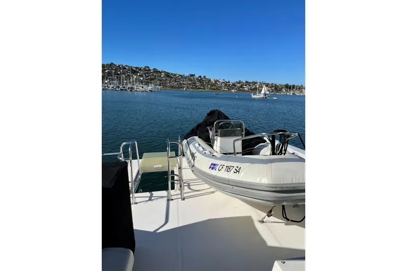 Slide: The Image of 2004 Meridian 490 Pilothouse with dinghy on deck, overlooking marina and sailboats. - 27